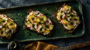 Kartoffelmad med rygeost, radiser, purløg og græskarkerneolie på rugbrød